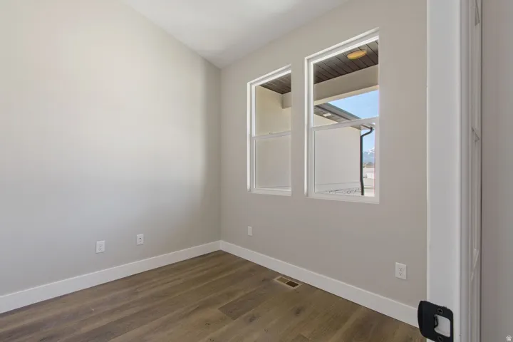 Two double-hung windows, wood-finish flooring, white trim, and light-toned wall paint