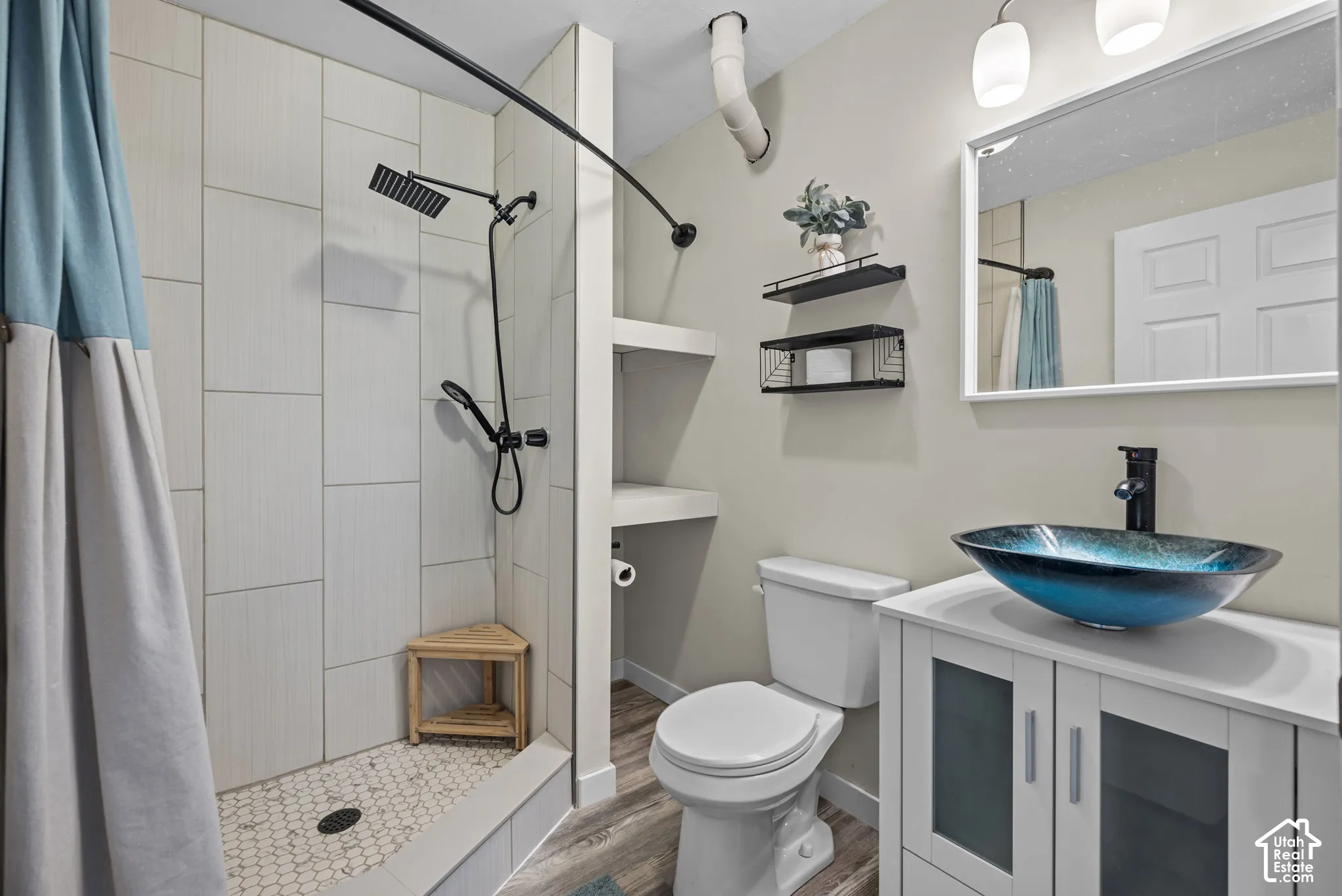 Shower with vertical-set tile surround and hexagonal floor tiles