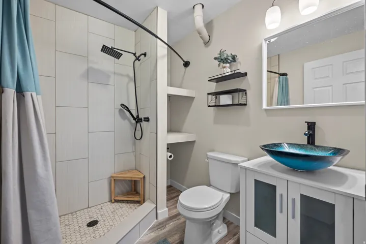 Shower with vertical-set tile surround and hexagonal floor tiles