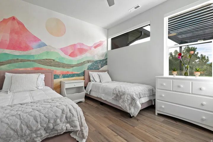 Wood-finish flooring, white walls, and a large window with a built-in blind