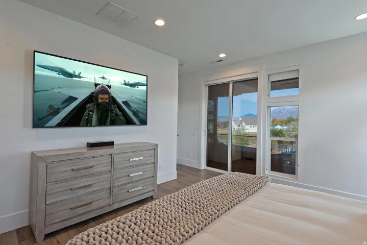 Recessed lighting, wood-finish flooring, white walls, and a sliding glass door