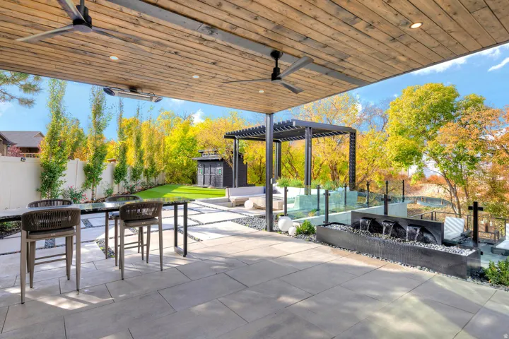 Covered patio with a wood-finish ceiling, integrated recessed lighting, and ceiling fans
