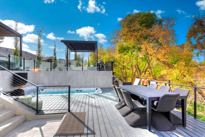Multi-level deck featuring a built-in spa, concrete stairs, and glass panel railing