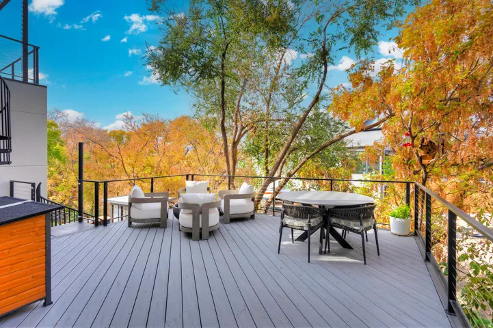Expansive outdoor deck featuring wood-finish flooring and black metal railings