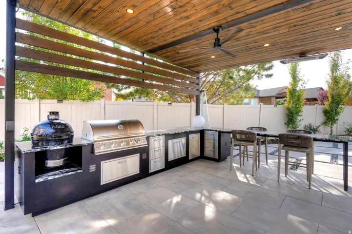 Covered outdoor patio featuring a wood plank ceiling with recessed lighting and a ceiling fan