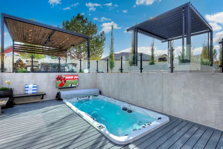 Outdoor deck with a swim spa, composite decking, and concrete retaining walls