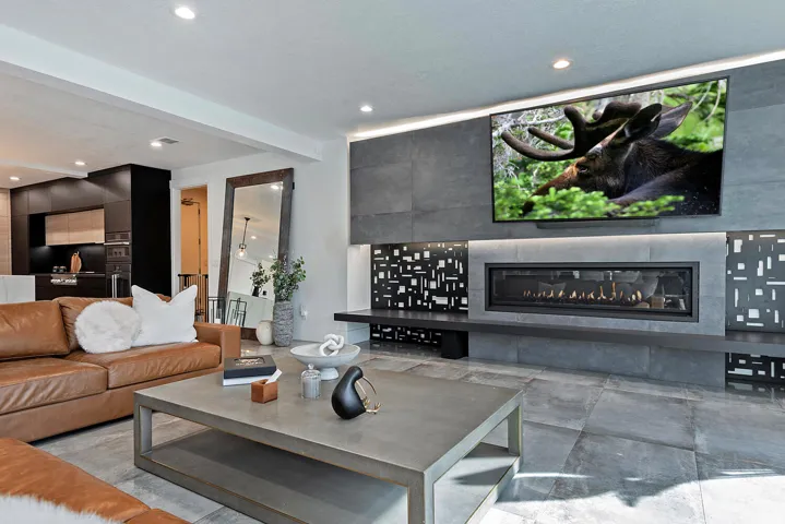 Tile flooring, recessed lighting, built-in linear fireplace, integrated media wall, and modern cabinetry