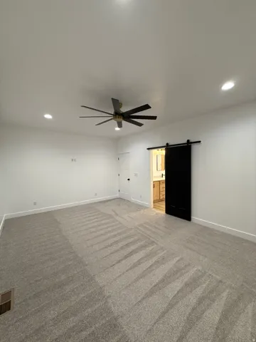 Spacious room with recessed lighting, a modern ceiling fan, and light-toned carpeting