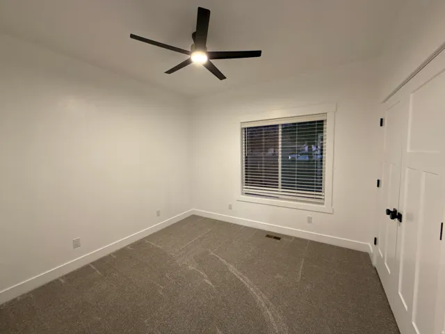 Recessed window with blinds, white trim, and white walls