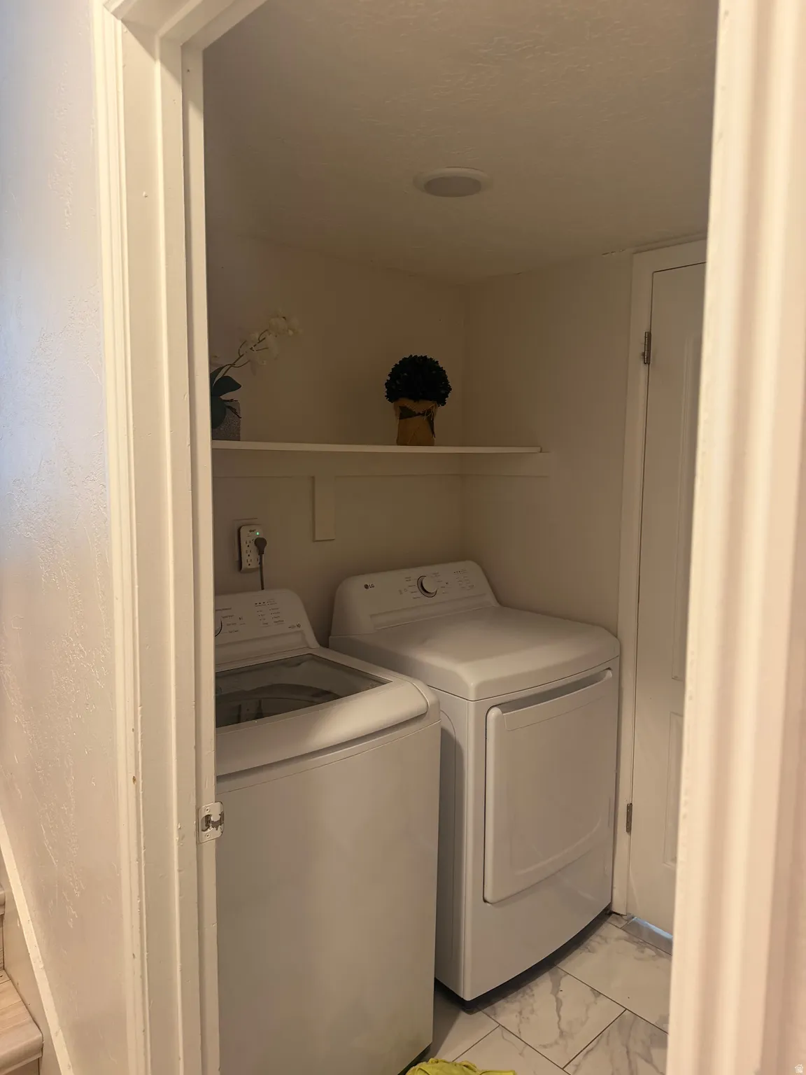 Utility closet with a built-in shelf, recessed ceiling lighting, and tile flooring