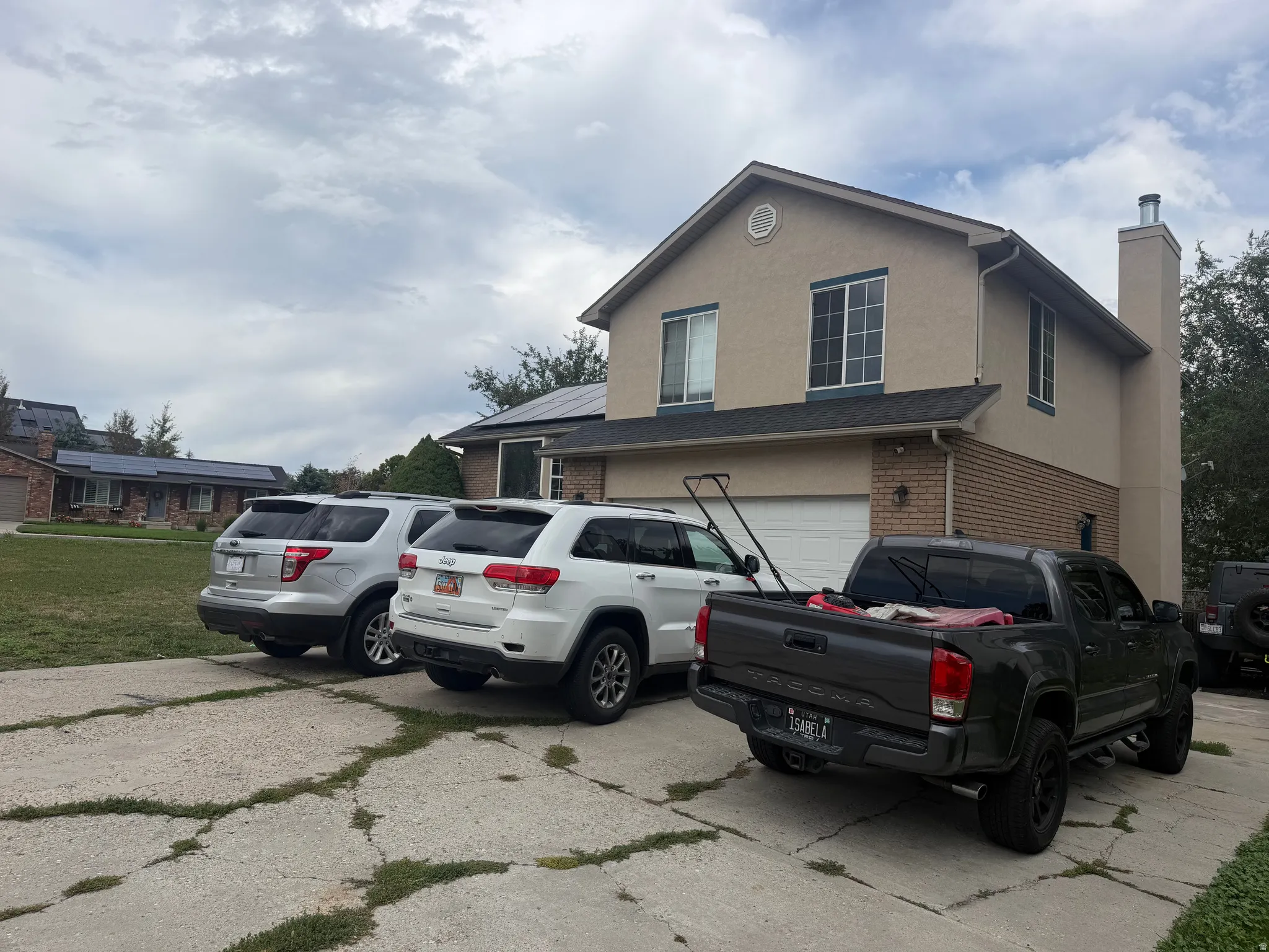 Stucco exterior with brick detailing, attached two-car garage, and a gabled roof