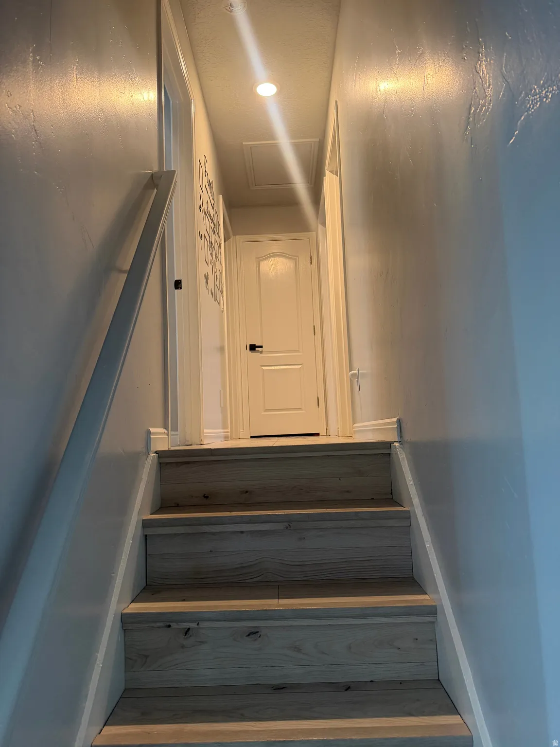 Wood-finish stairs with a white handrail