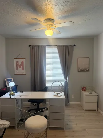 Ceiling fan with integrated lighting, window with horizontal blinds, light wood-finish flooring, and light gray wall paint