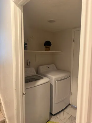 Utility closet with a built-in shelf, recessed ceiling lighting, and tile flooring