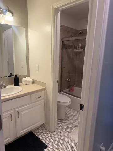 Bathroom featuring a vanity with white cabinetry, a single basin sink, and a light-toned countertop