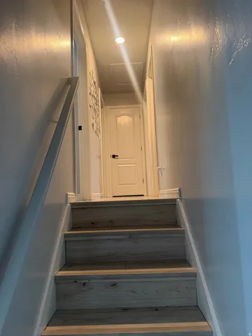 Wood-finish stairs with a white handrail