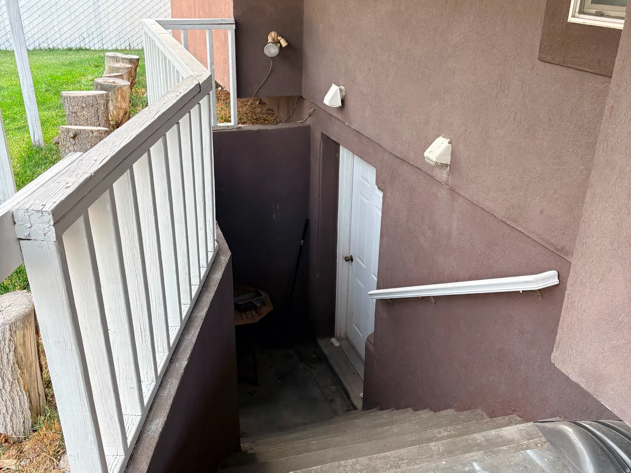 Exterior entry with stucco finish and a white door
