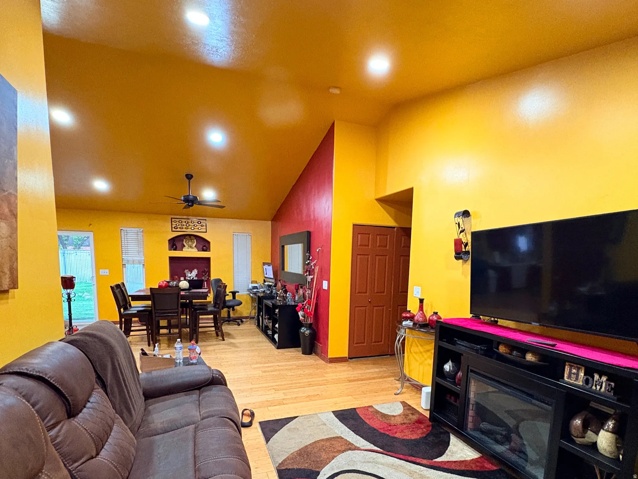 Vaulted ceilings, recessed lighting, and wood-finish flooring define this open-concept space