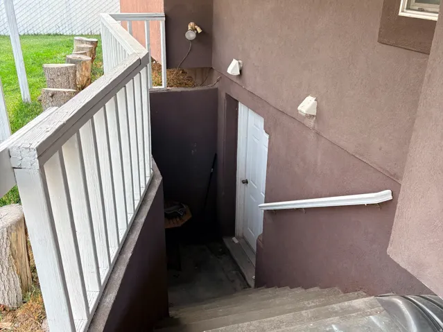 Exterior entry with stucco finish and a white door