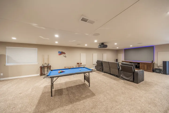 The basement family room has recessed lighting, large projection screen, wall-mounted projector,