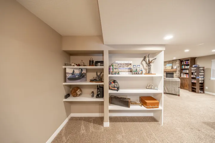 Built-in shelving units as you enter the basement family room has recessed lighting, and neutral wall paint