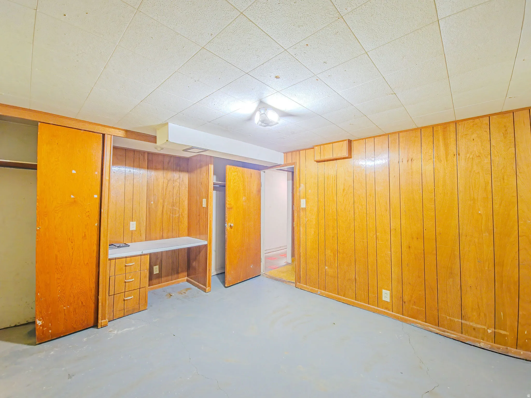 Wood-paneled room with a built-in desk featuring drawers and a laminate countertop