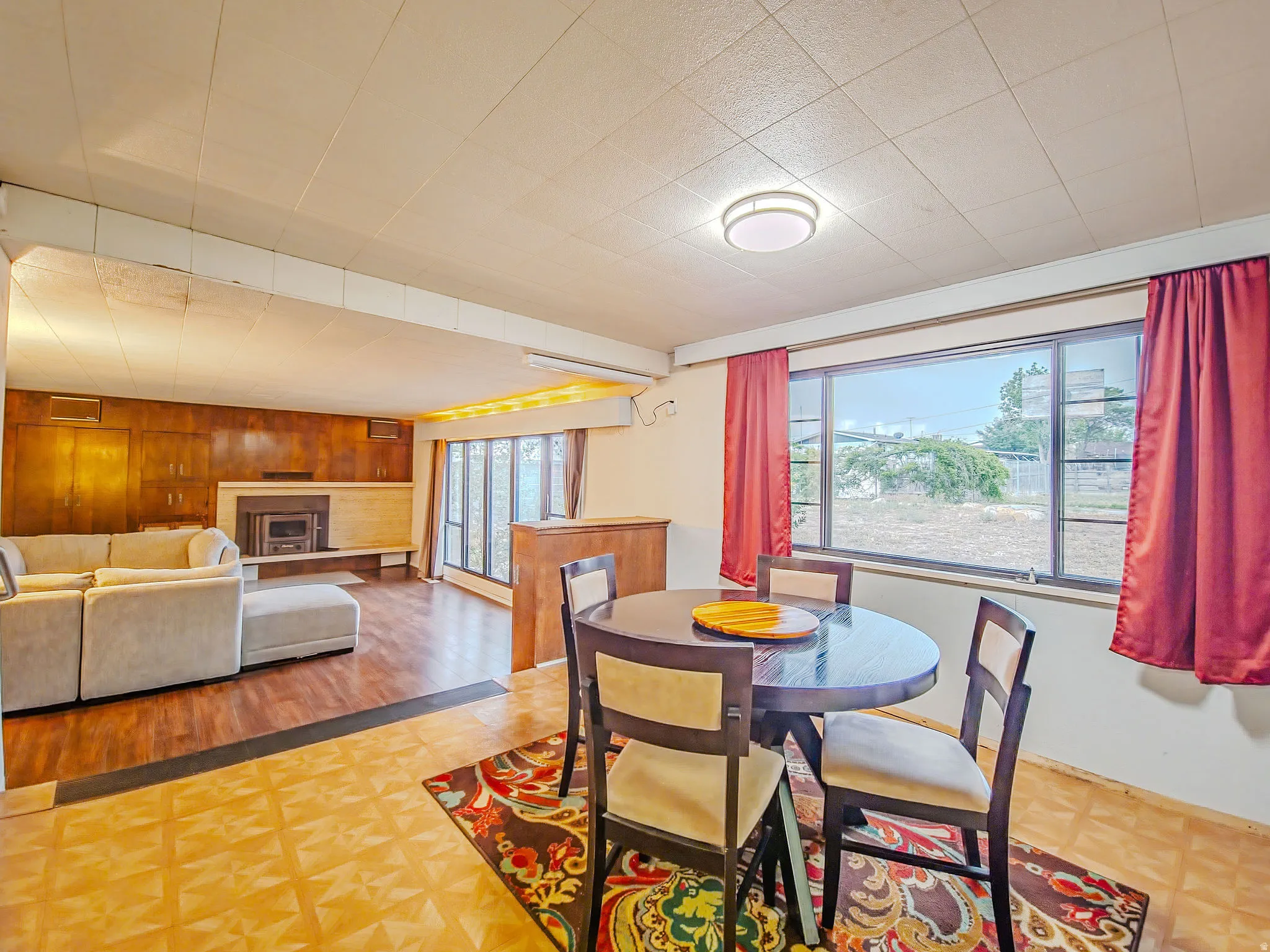 Wood-finish flooring, wood paneling, fireplace, recessed lighting, and large windows