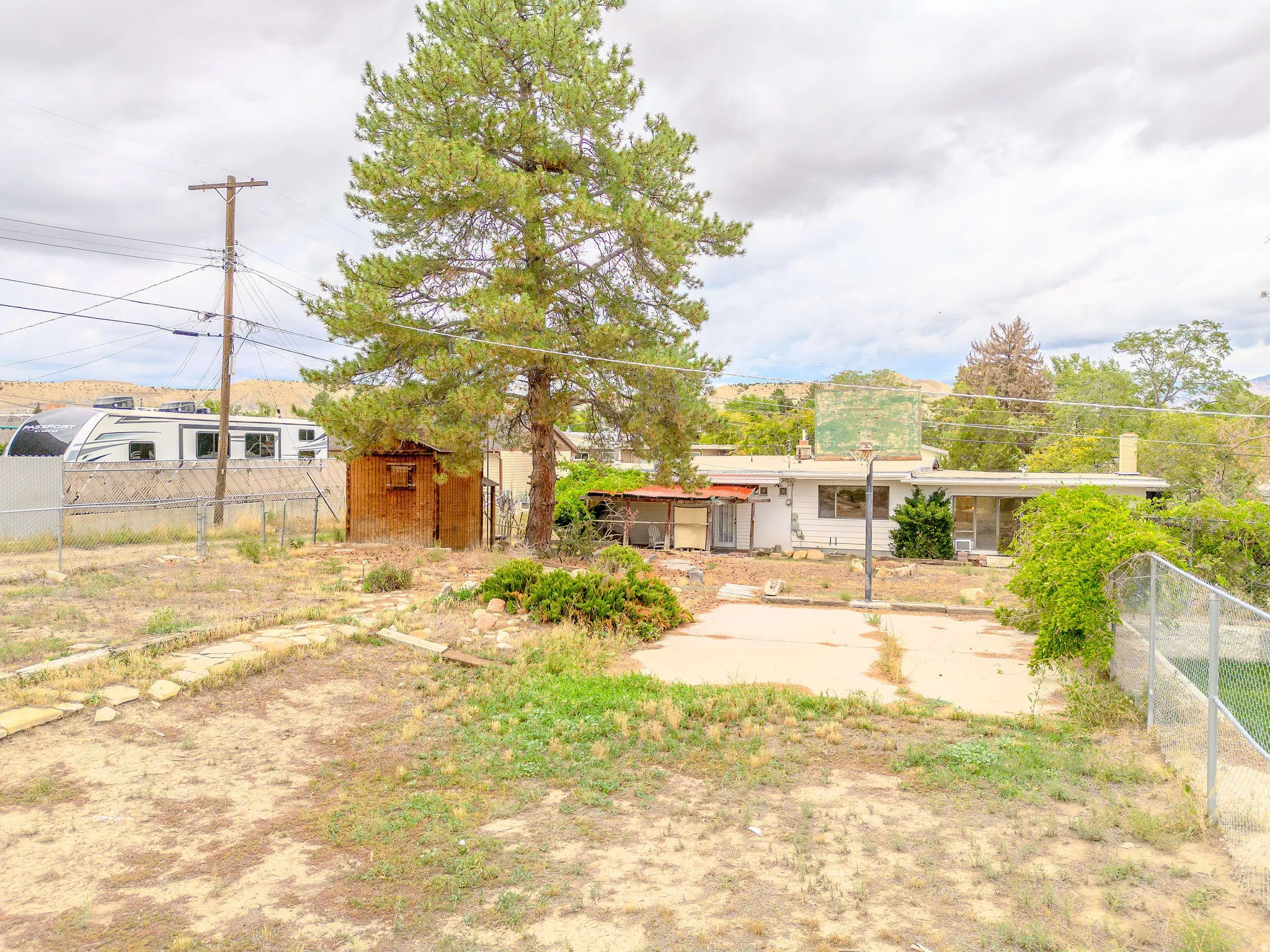 Expansive outdoor space featuring a concrete pad and chain-link fencing
