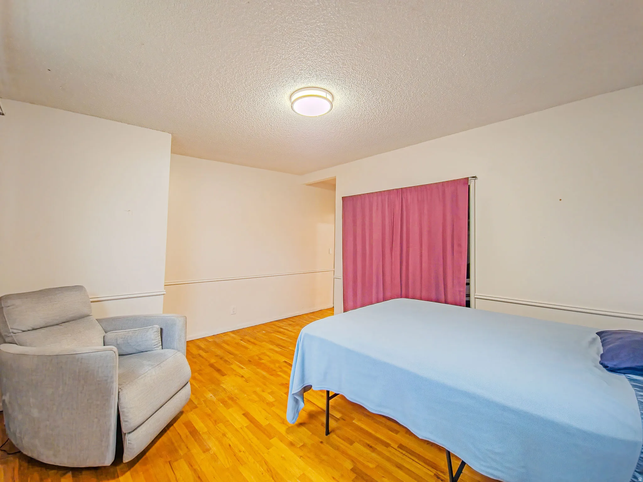 Hardwood flooring, crown molding, and a flush-mount ceiling light fixture