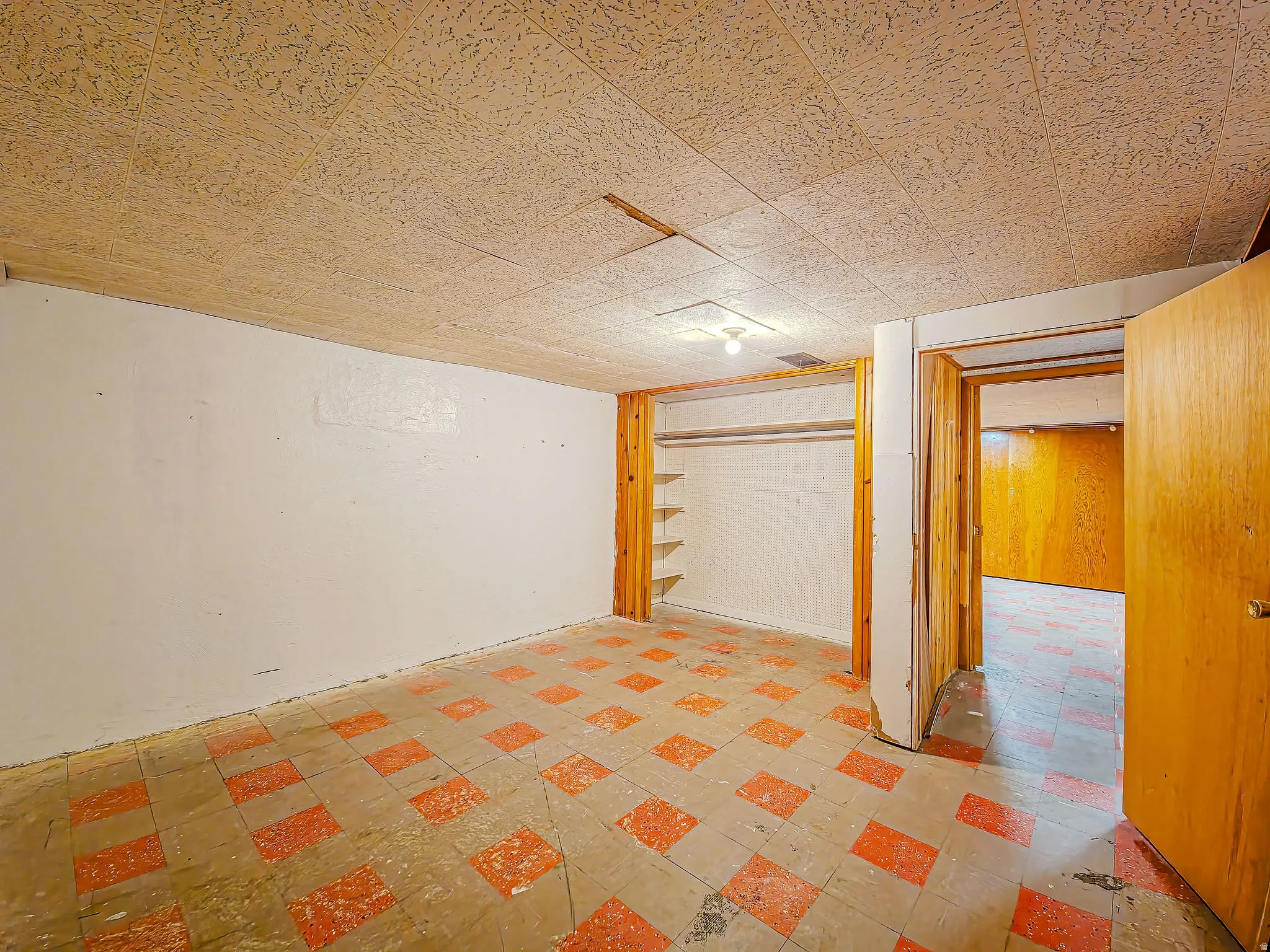 Room featuring patterned floor tiles, white painted walls, and a built-in closet with shelving and hanging rod