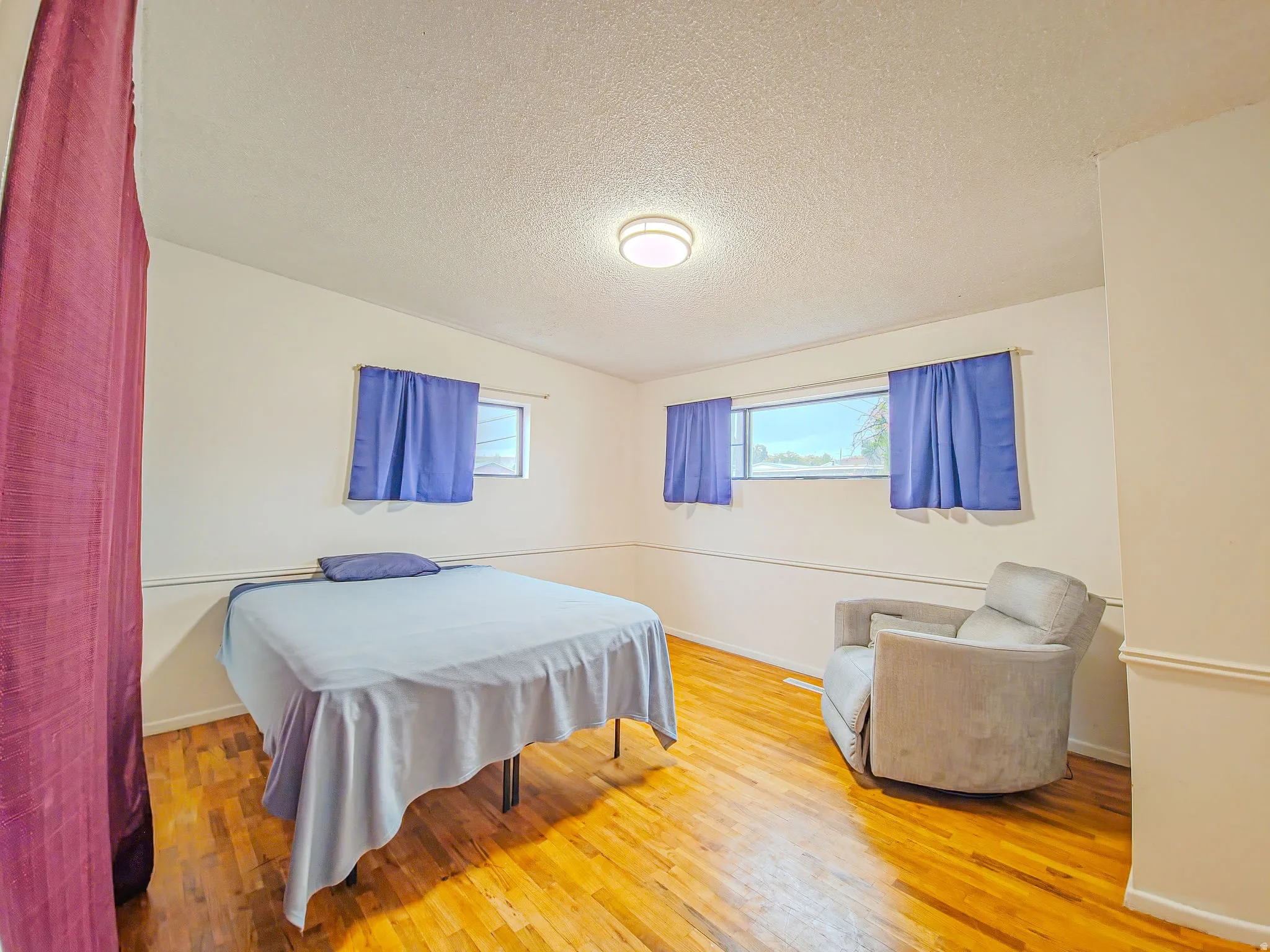 Wood-finish flooring, multiple windows, and overhead lighting