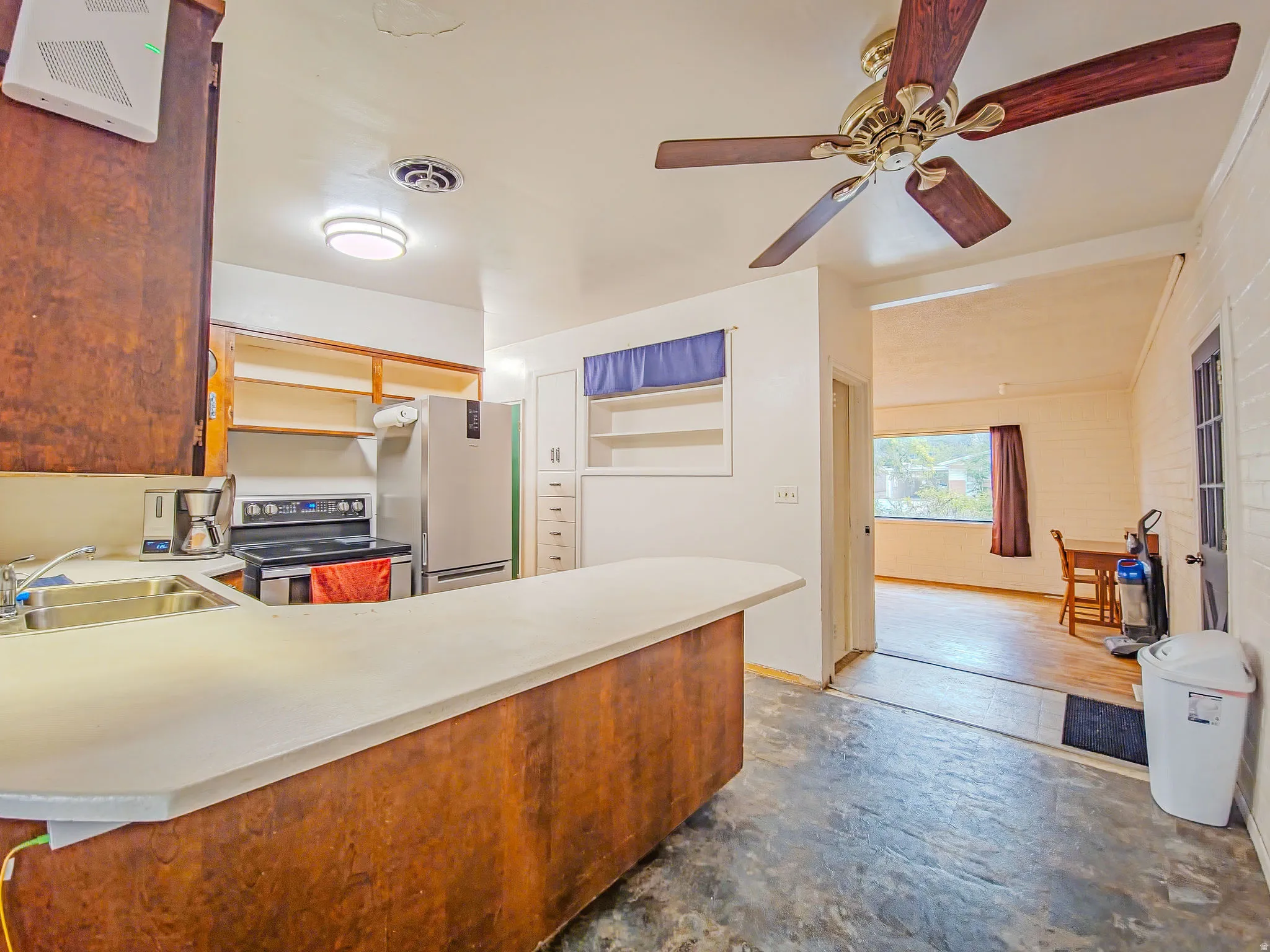 Kitchen featuring wood-finish cabinetry, stainless steel sink, and a ceiling fan