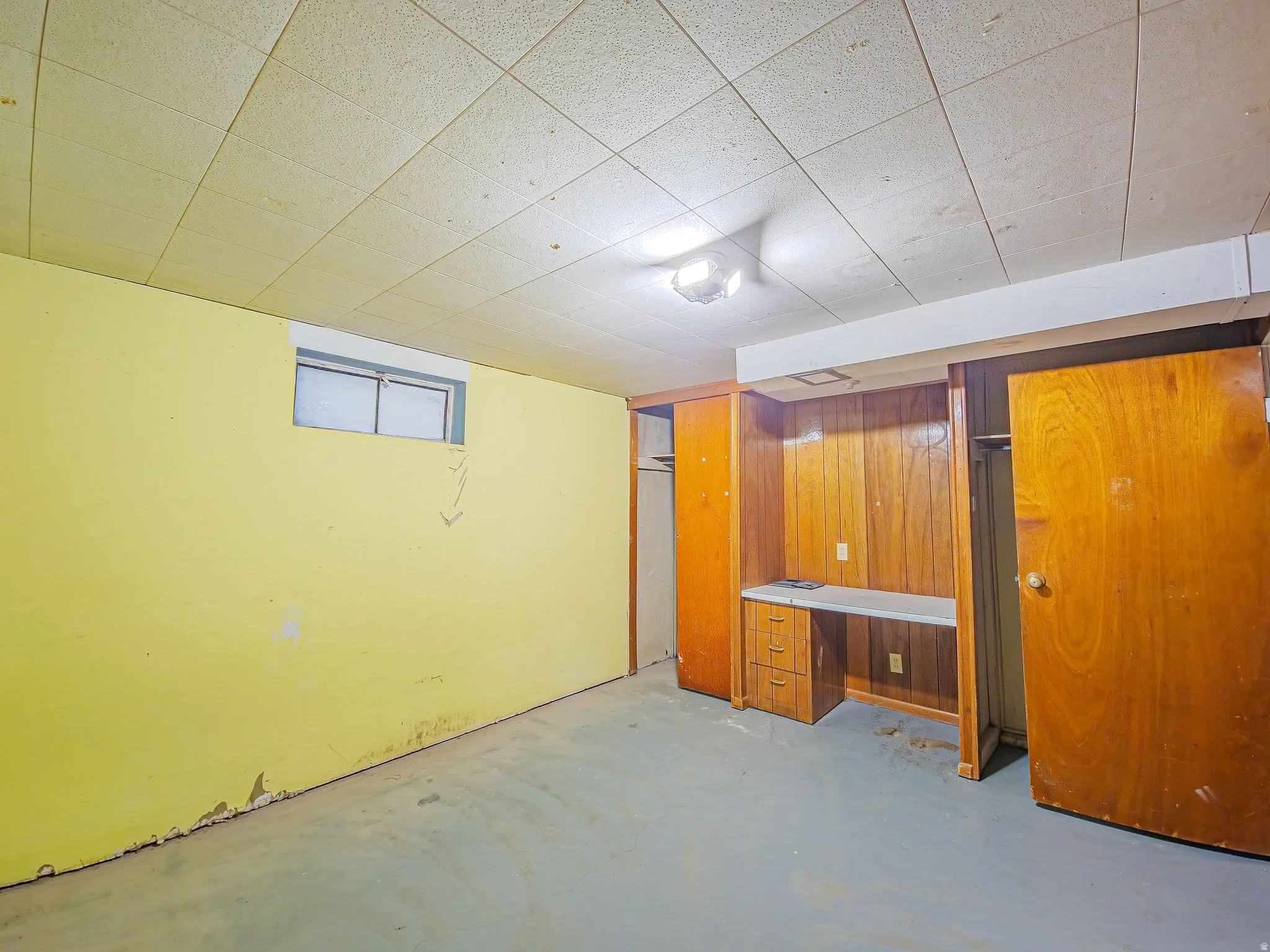 Built-in desk area with wood paneling, integrated storage, and overhead lighting