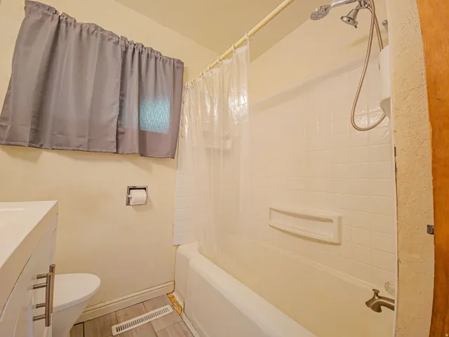 White tiled shower surround with an integrated soap dish and a tub