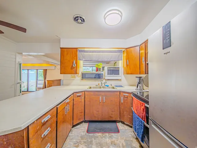 Kitchen with wood-finish cabinetry, solid surface countertops, and integrated sink
