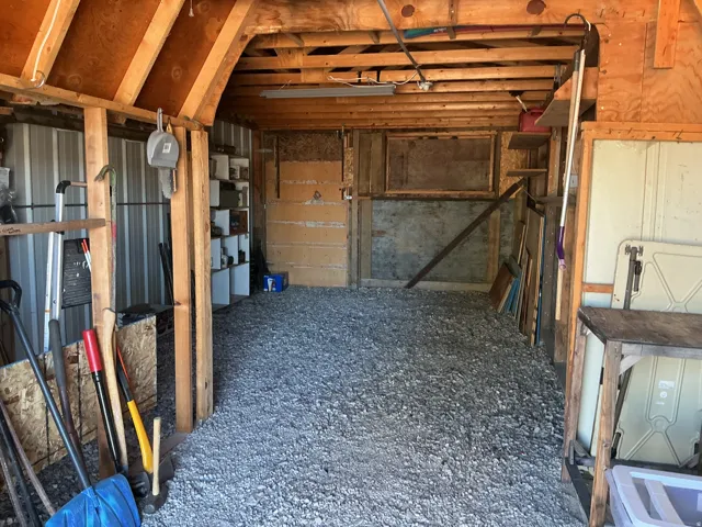 Exposed wood beam ceiling, gravel flooring, and open wood shelving