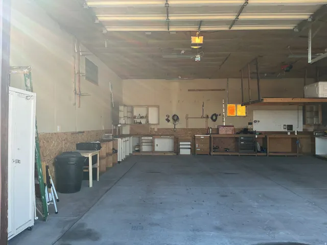 Spacious garage with concrete flooring, built-in shelving, and a robust overhead storage system