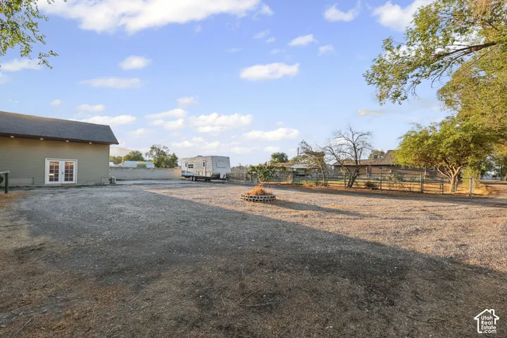 Expansive gravel lot with a detached structure featuring double glass doors