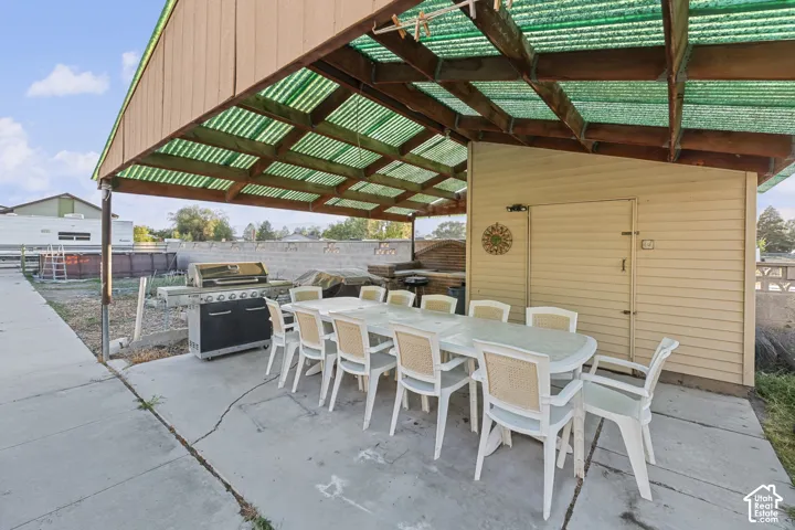 Covered patio area with concrete hardscaping and a built-in outdoor cooking station
