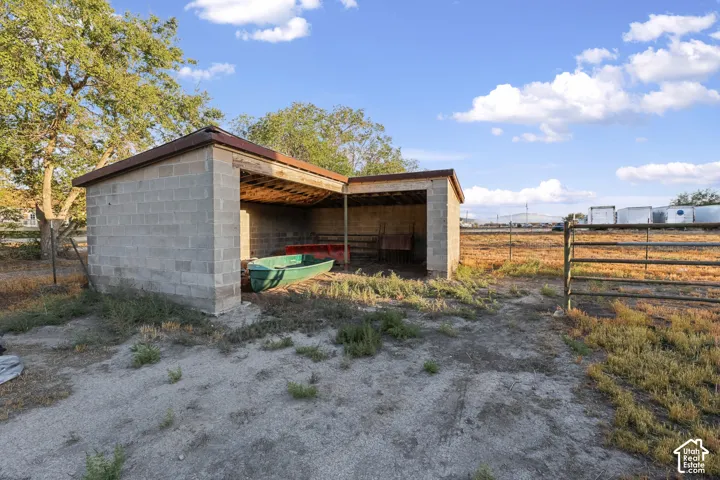 Concrete block structure with an open-sided shed, a flat roof, and a wood-slat ceiling