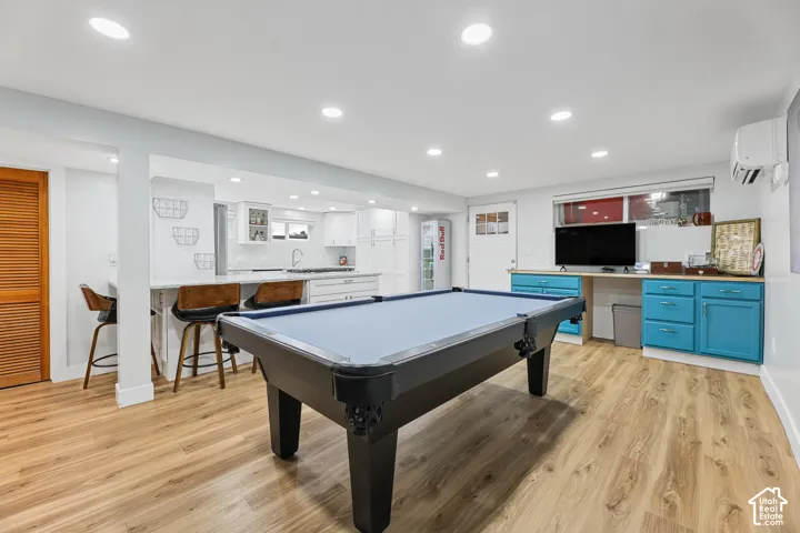 Wood-finish flooring, recessed lighting, and a white kitchen with a peninsula