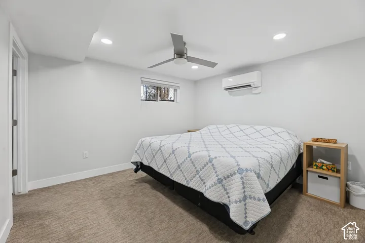 Recessed lighting, ceiling fan, wall-mounted air conditioning unit, window, and low-pile carpeting