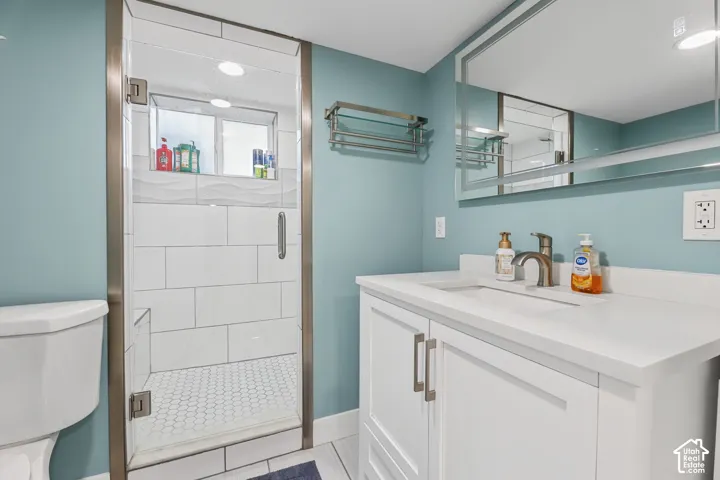 Glass-enclosed shower with subway tile surround and hexagonal tile flooring