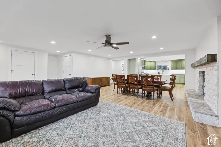 Spacious living area with wood-finish flooring, recessed lighting, and a ceiling fan