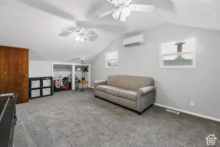 Angled ceiling featuring two ceiling fans, split air conditioning unit, and two windows