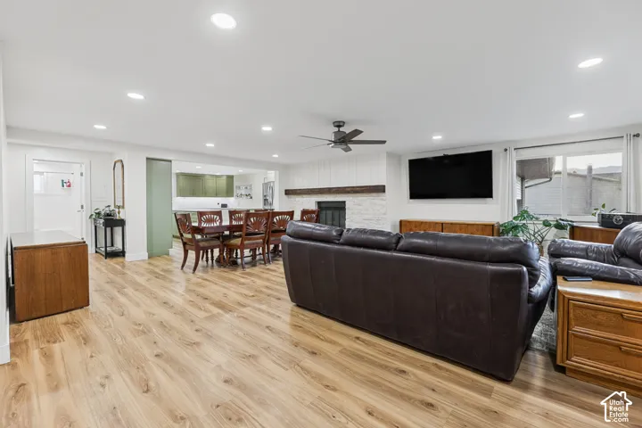 Recessed lighting, wood-finish flooring, fireplace with a wood mantel, ceiling fan, and sliding glass door