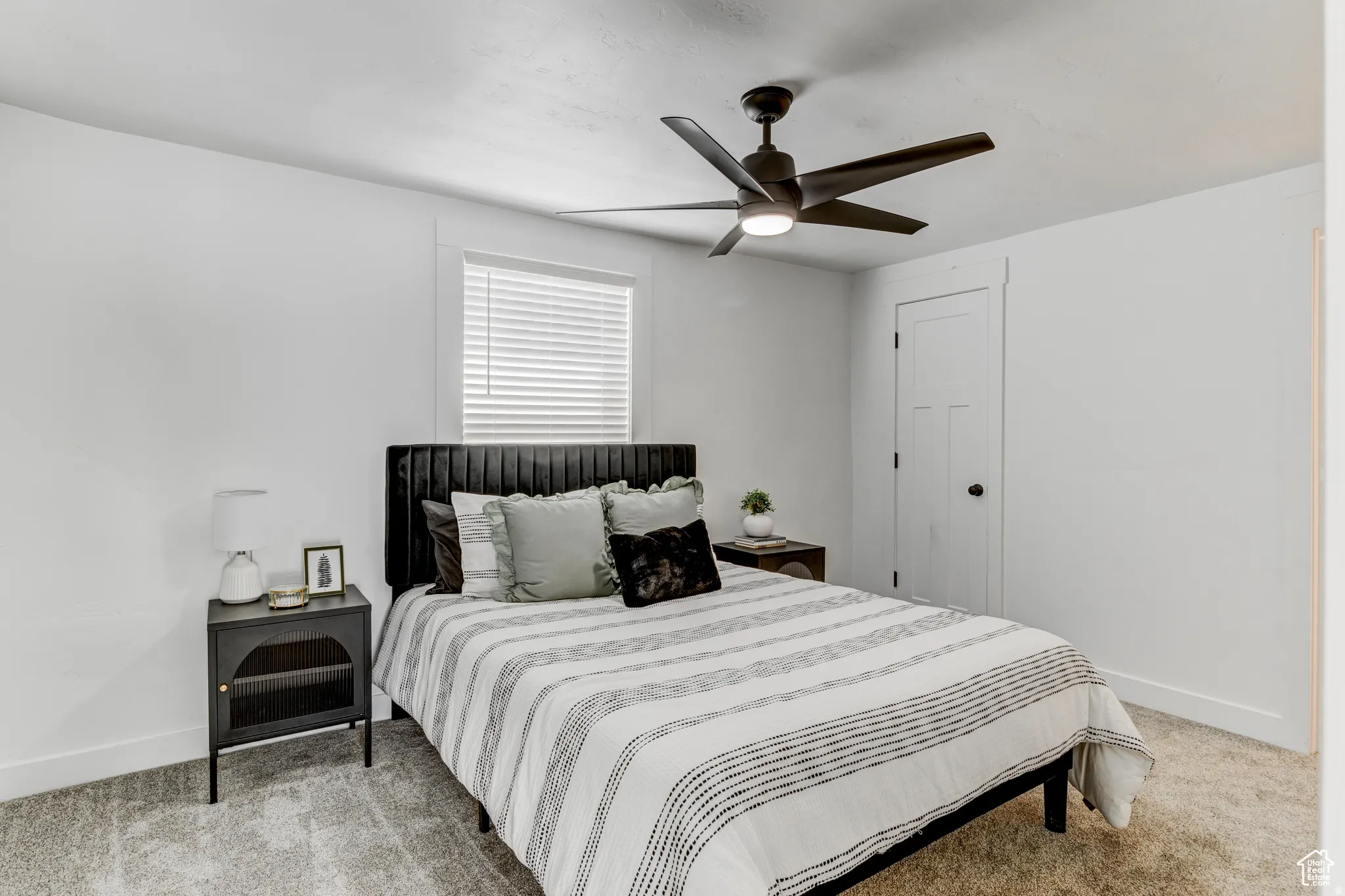 Contemporary ceiling fan with integrated lighting, window with blinds, panel door, and wall-to-wall carpeting