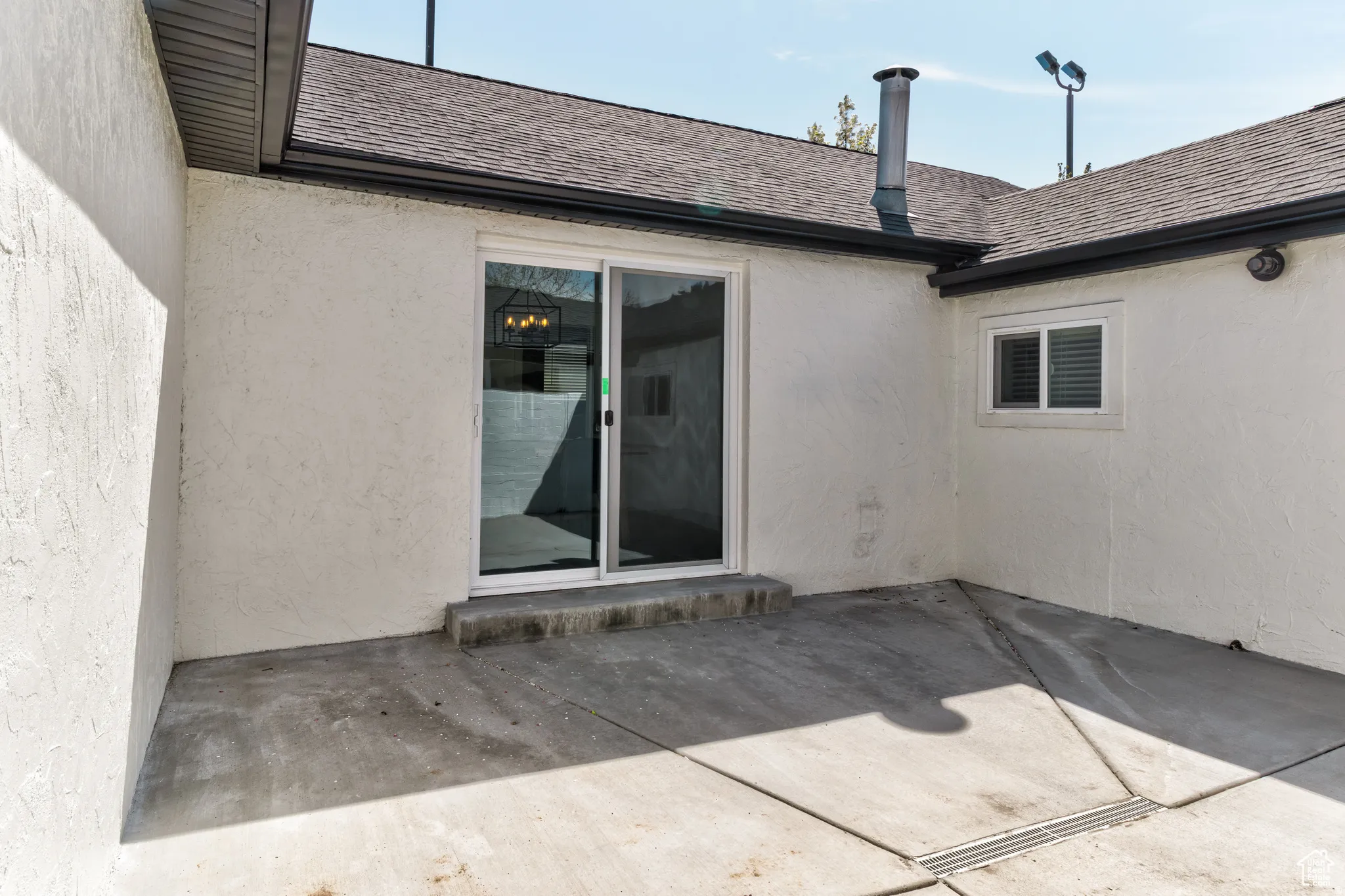 Concrete patio featuring a sliding glass door and a single-hung window