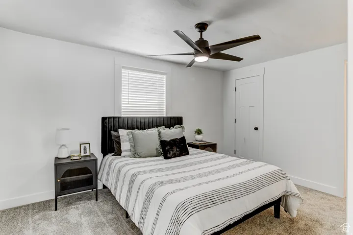 Contemporary ceiling fan with integrated lighting, window with blinds, panel door, and wall-to-wall carpeting
