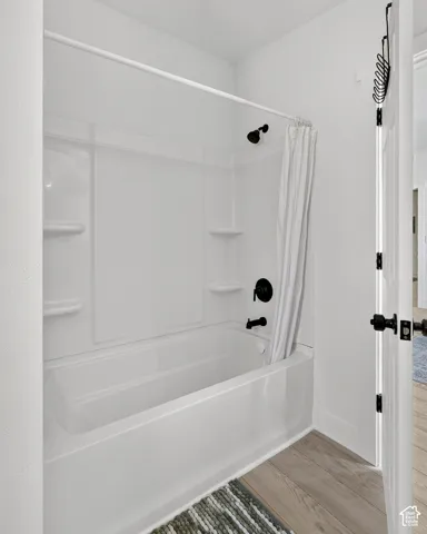 White bathtub and shower combination with matte black fixtures